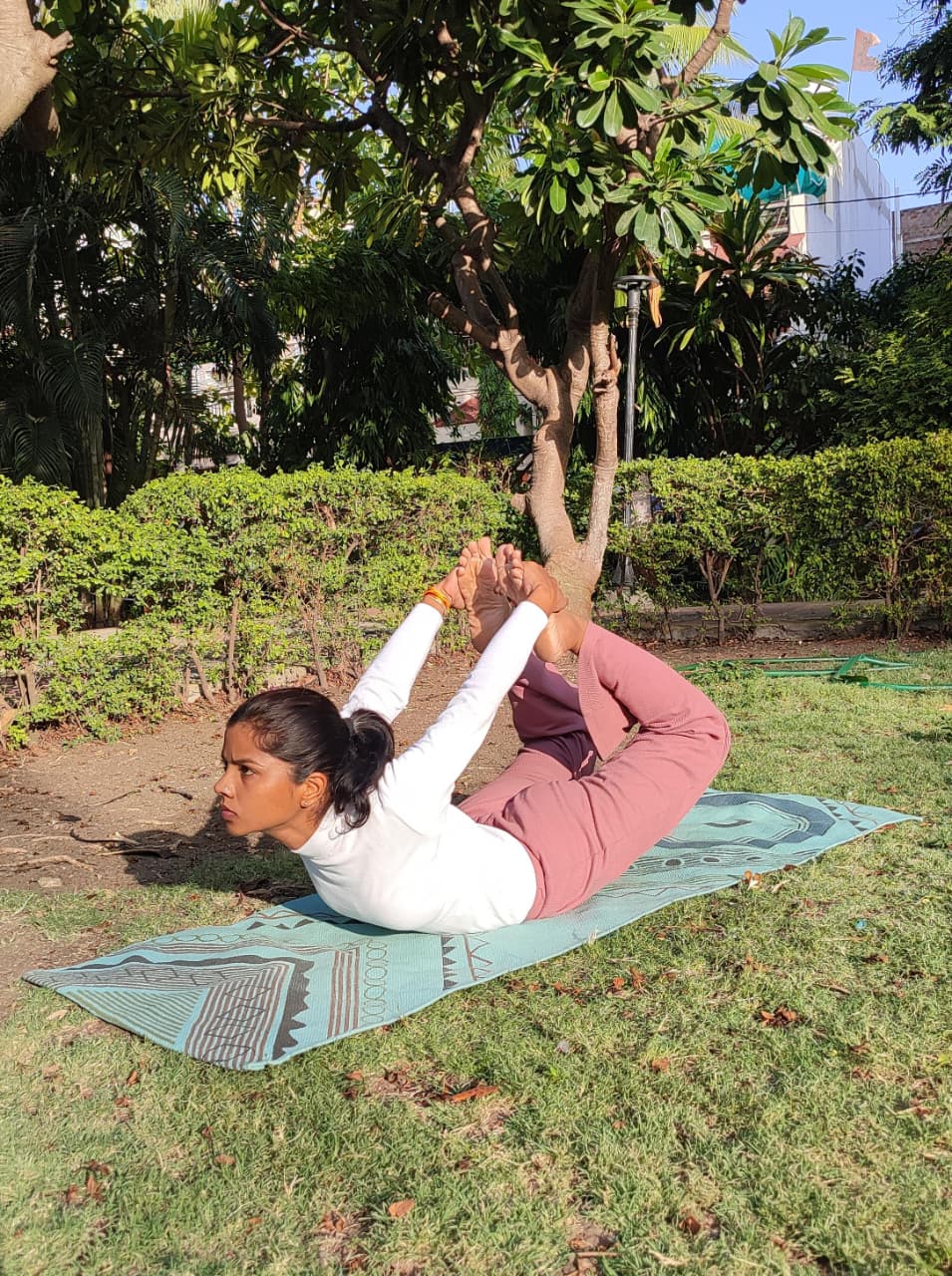 Dhanurasana bow pose in garden